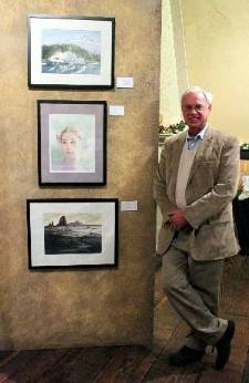 Jeff waters stands to the side of three of his prized watercolor works.