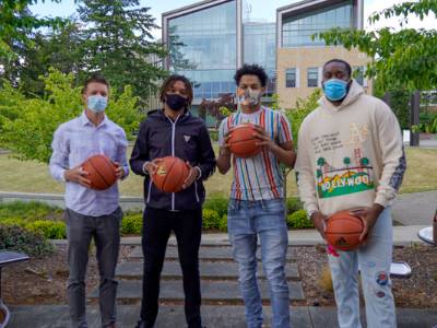 Four students holding basketballs
