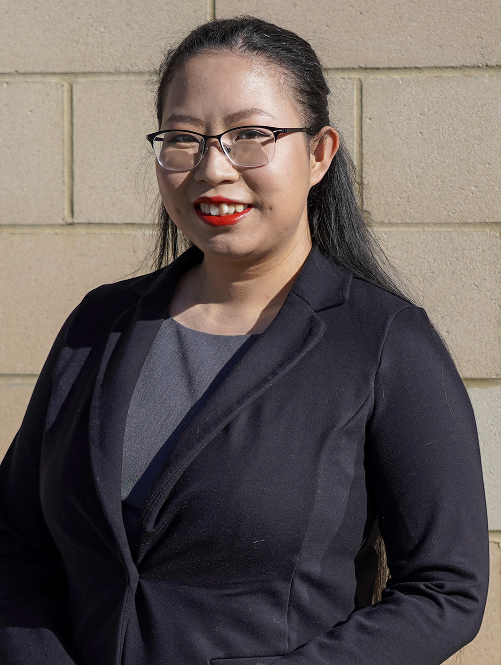 Woman in suit and glasses smiling